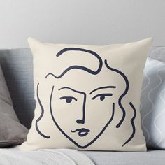 a black and white drawing of a woman's face on a cream colored pillow