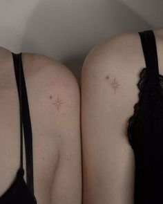 two women with small tattoos on their backs, one is wearing a bra and the other has