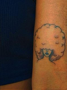 a woman's arm with a tattoo on it that has a hairdow