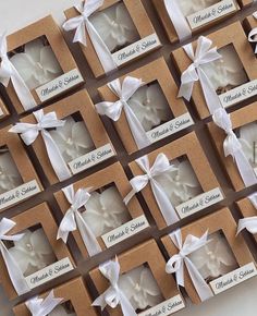 wedding favors in boxes with white ribbons and bows on the top one is for each guest