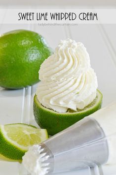 lime whipped cream in a cup next to two limes on a white table with the words, sweet lime whipped cream