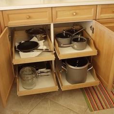 an open cabinet with pots and pans in it