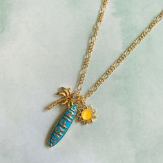 "Summer fun surfing charm necklace. Chain is 18\" with 3\" extension Enamel. Surfing pendant with Sun, Palm tree charm. Surfing charm size is 33mm X 9mm Lead and Cadmium safe" Adjustable Beach Charm Necklace, Surfing Jewelry, Ocean-inspired Gold Charm Necklaces For Summer, Surfing Necklace, Summer Beach Ocean-inspired Charm Necklace, Surf Necklace, Kitesurfing, Kite Surfing, Necklace Chain