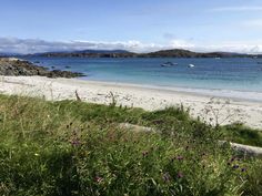 a sandy beach with boats in the water