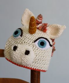 a crocheted hat with a unicorn's face and a horn on it