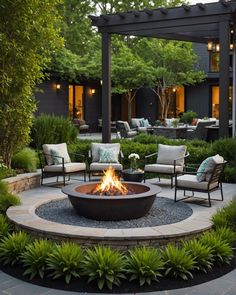 an outdoor fire pit surrounded by chairs and plants in the middle of a patio area