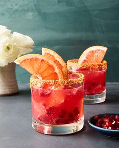 two glasses filled with blood oranges and cranberry juice on top of a table