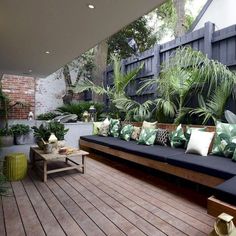 a wooden deck with couches and plants on it