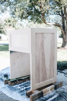 an unfinished cabinet sitting on top of a piece of wood