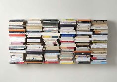 a large number of books stacked on top of each other in the shape of a wall