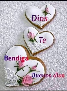 two heart shaped cookies decorated with flowers and the words dios te bendiga