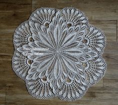 a white doily is sitting on a wooden floor