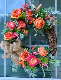 an orange and pink wreath on a window sill