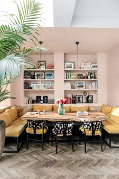 a living room filled with lots of furniture and bookshelves next to a potted plant