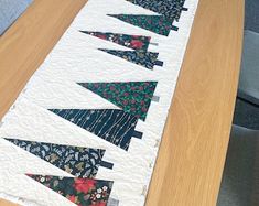 a quilted table runner with christmas trees on it