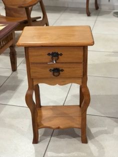 a small wooden table sitting on top of a tile floor