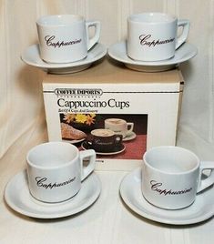 three coffee cups and saucers are sitting in front of a box with the caption cappuccino cups