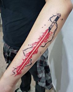 a person with a tattoo on their arm holding onto a red and black ink pen