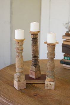 three wooden candlesticks sitting on top of a table