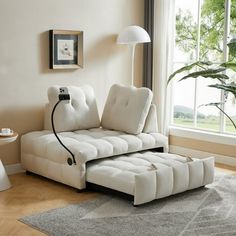 a living room with a couch, table and lamp on the floor in front of a window