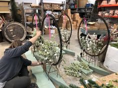 a woman working on some plants in a shop