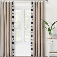 a living room with white walls and blue checkered drapes on the windowsill