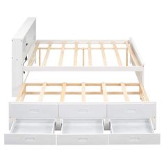 a white bed frame with three drawers on each side and an open drawer underneath it