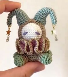 a crocheted stuffed animal is being held by someone's hand with a keychain