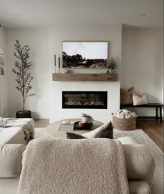 a living room filled with furniture and a flat screen tv mounted on the wall above a fire place