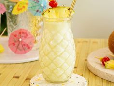 a pineapple drink in a tall glass with a straw and cherry on the top