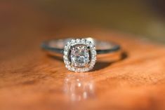 a diamond ring sitting on top of a wooden table