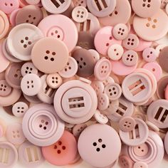 many pink and white buttons are scattered together