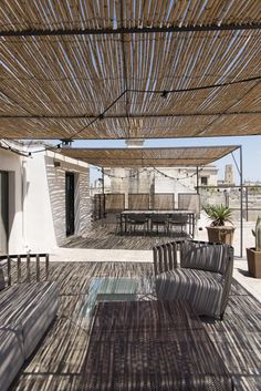 an outdoor covered patio with chairs and tables