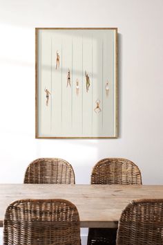 a dining room table with wicker chairs and a painting on the wall above it