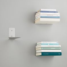 three books are stacked on top of each other in front of a wall mounted device