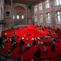 many people are laying on the floor in an old building with red tarp covering them