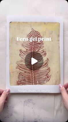 two hands holding up a book with an image of a feather on it and the title fern gel print