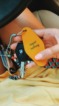 a woman holding a keychain with the word regio nothing written on it