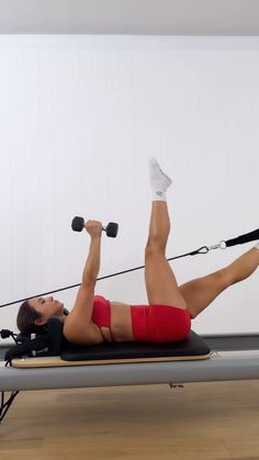 a woman is doing exercises on a rowing machine