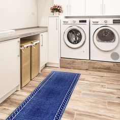 a washer and dryer in a room with wood flooring on the ground