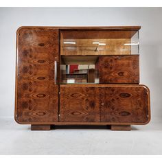 an old wooden cabinet with glass doors and drawers