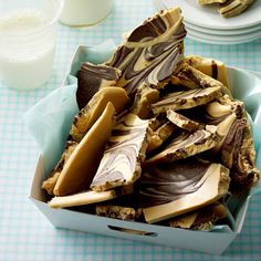 a box full of chocolate and peanut butter crackers on top of a table with plates