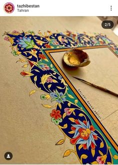 an intricately decorated tile with a brush and mirror on it's side, next to a pair of scissors