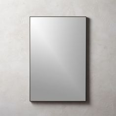 a square mirror mounted to the side of a wall