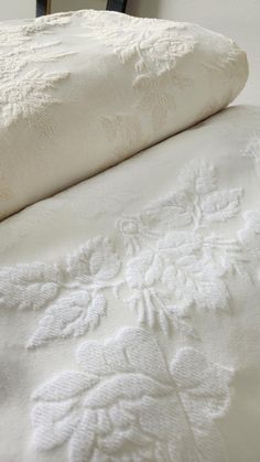 an unmade bed with white sheets and pillows