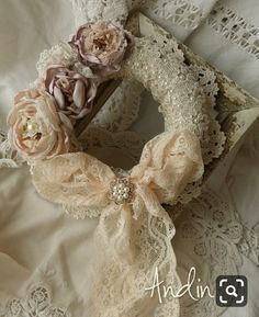 a close up of a cloth wreath on a lace doily with flowers in it