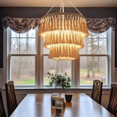 a chandelier hanging over a table in front of a window