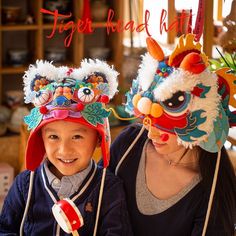 a woman and child wearing chinese headgear with the caption tiger head hat