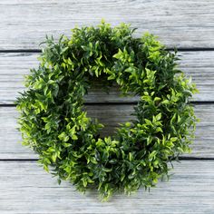 a green wreath sitting on top of a wooden table