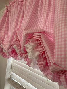 pink and white checkered curtains hanging from a window